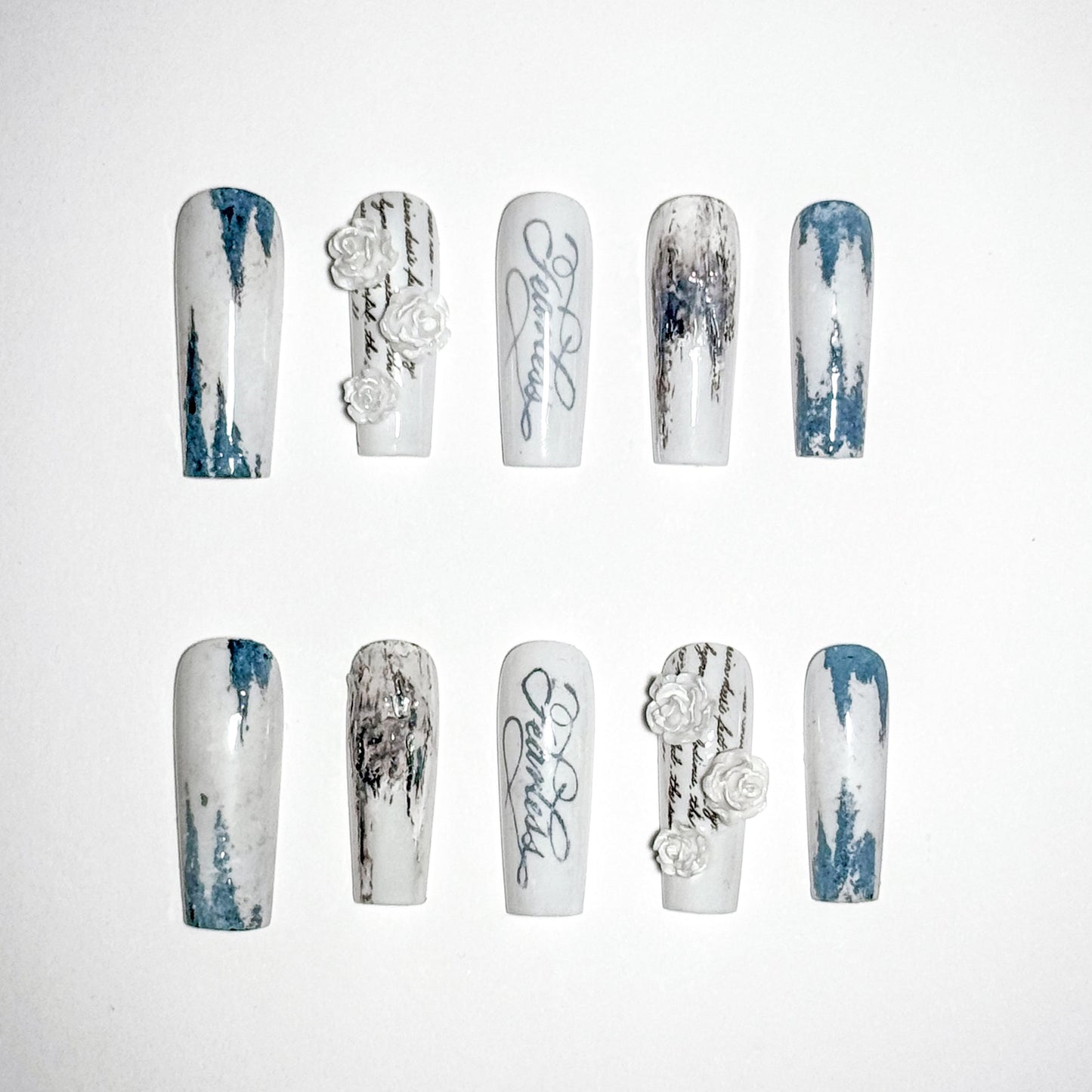 Set of nail art designs with white and blue patterns on a white background