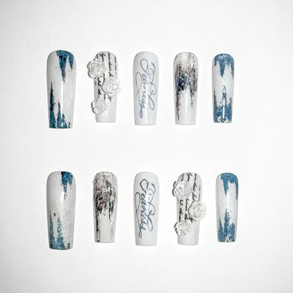 Set of nail art designs with white and blue patterns on a white background