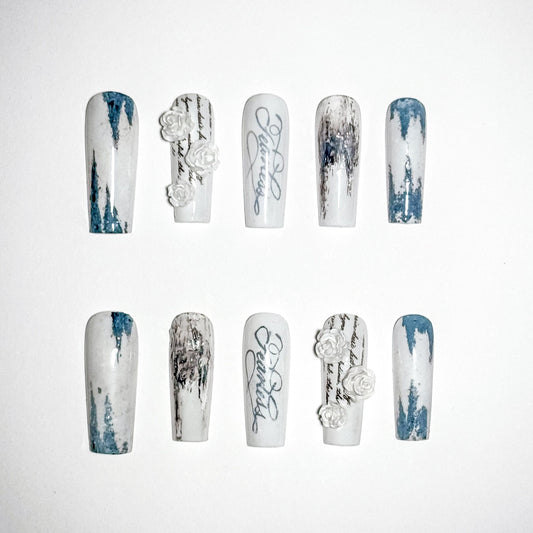 Set of nail art designs with white and blue patterns on a white background