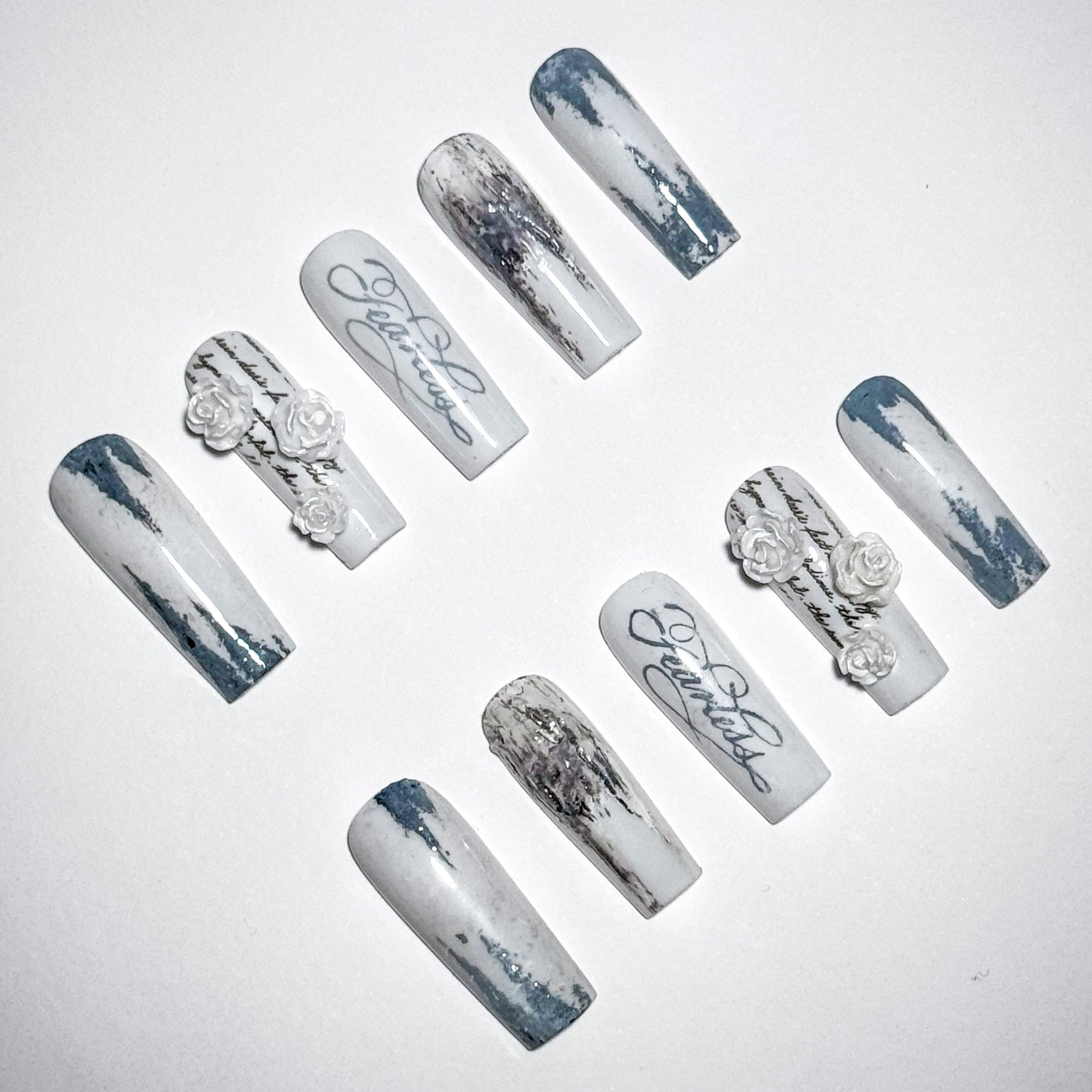 Set of decorative nails with marble effect and floral designs on a light gray background