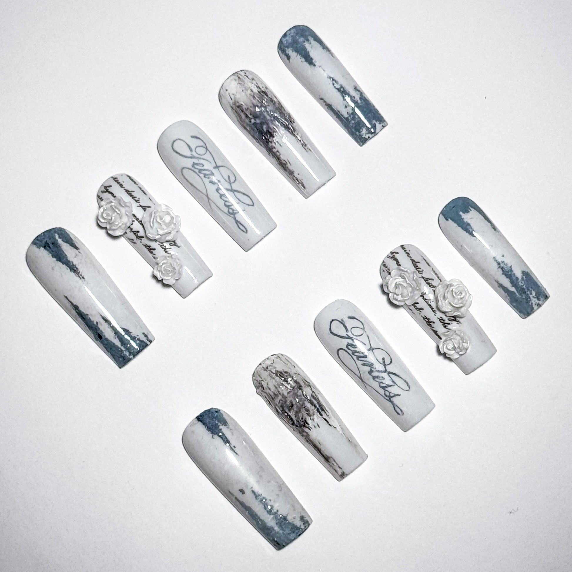 Set of decorative nails with marble effect and floral designs on a light gray background